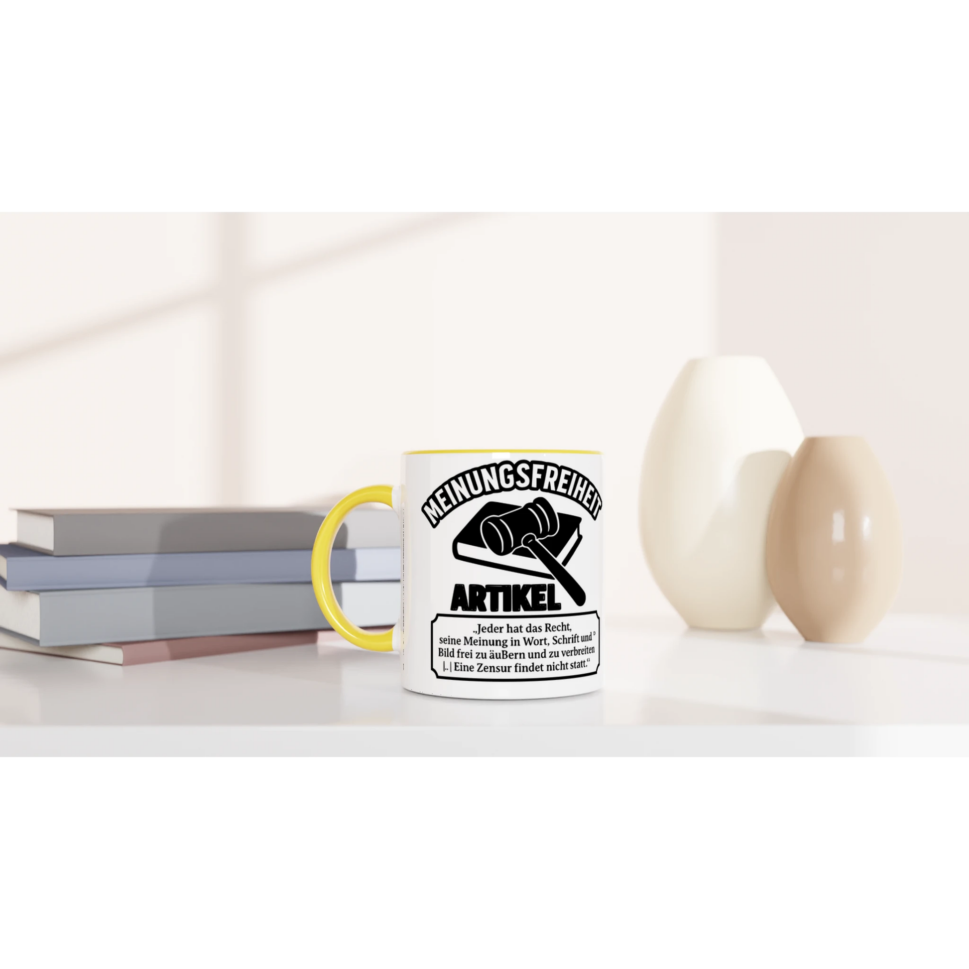 Weiße bedruckte kaffeetasse bestellen mit gelbem Griff und schwarzem text über meinungsfreiheit auf einem Tisch