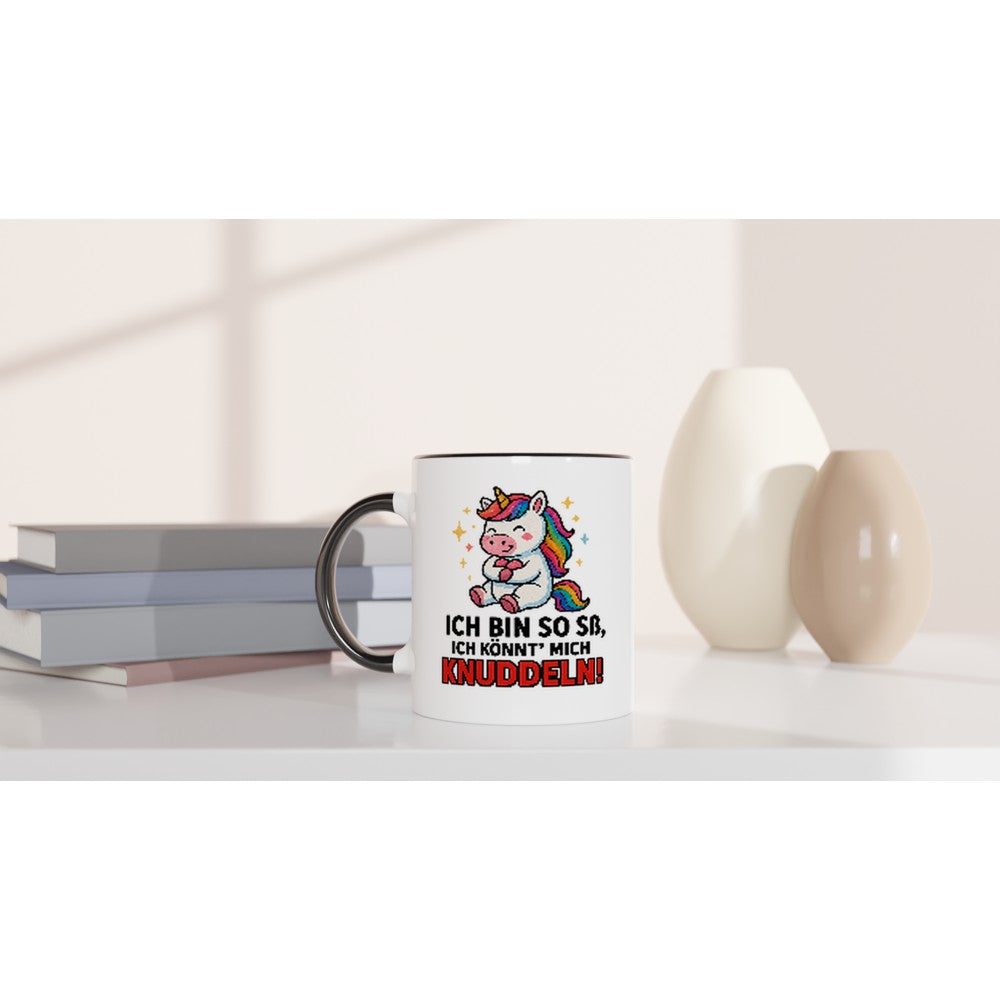 Einhorn Tasse mit Spruch Ich bin so süß ich könnt mich knuddeln von Wupperlike auf weißem Tisch