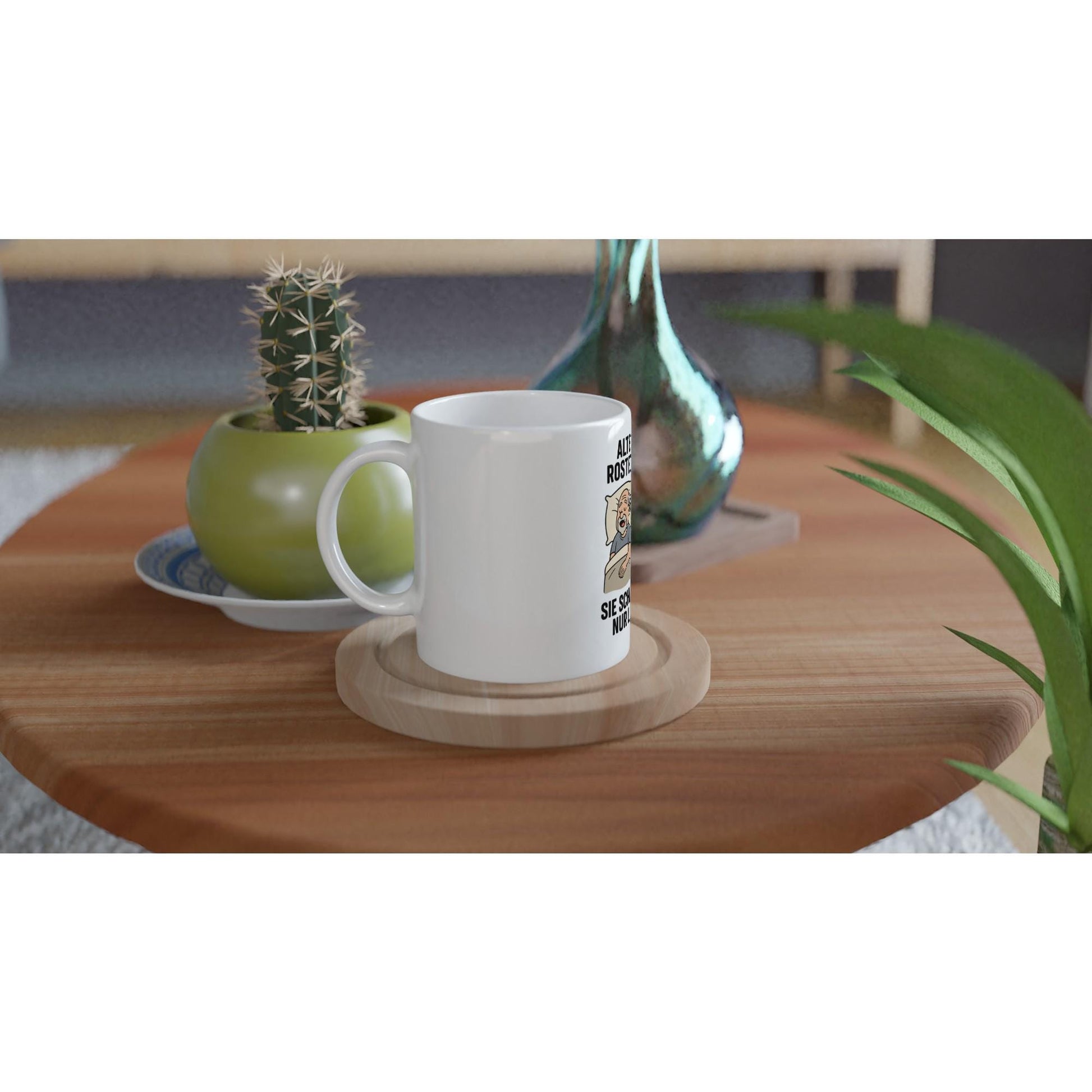 Weiße Geschenkidee für Paare Tasse auf Holzuntersetzer neben grüner Zimmerpflanze und Kaktus
