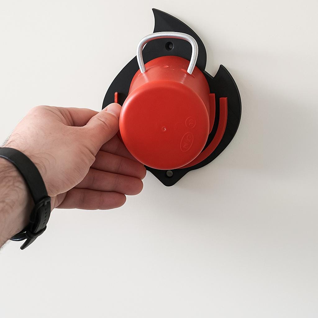 Halterung für gasflaschenkappen wohnwagen mit roter Kappe und Hand an weißer Wand montiert
