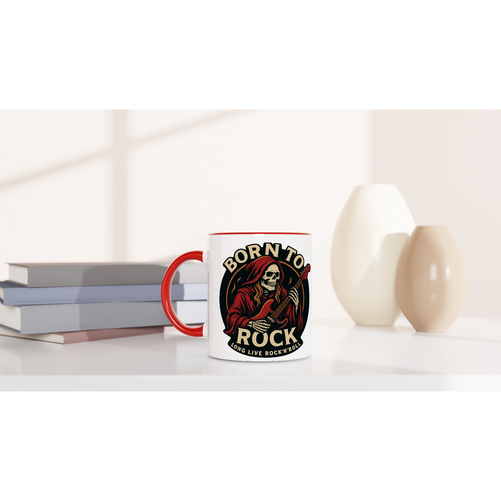 Wupperlike Tasse Born to Rock Geschenk mit rotem Henkel und coolem Rockmotiv neben Büchern